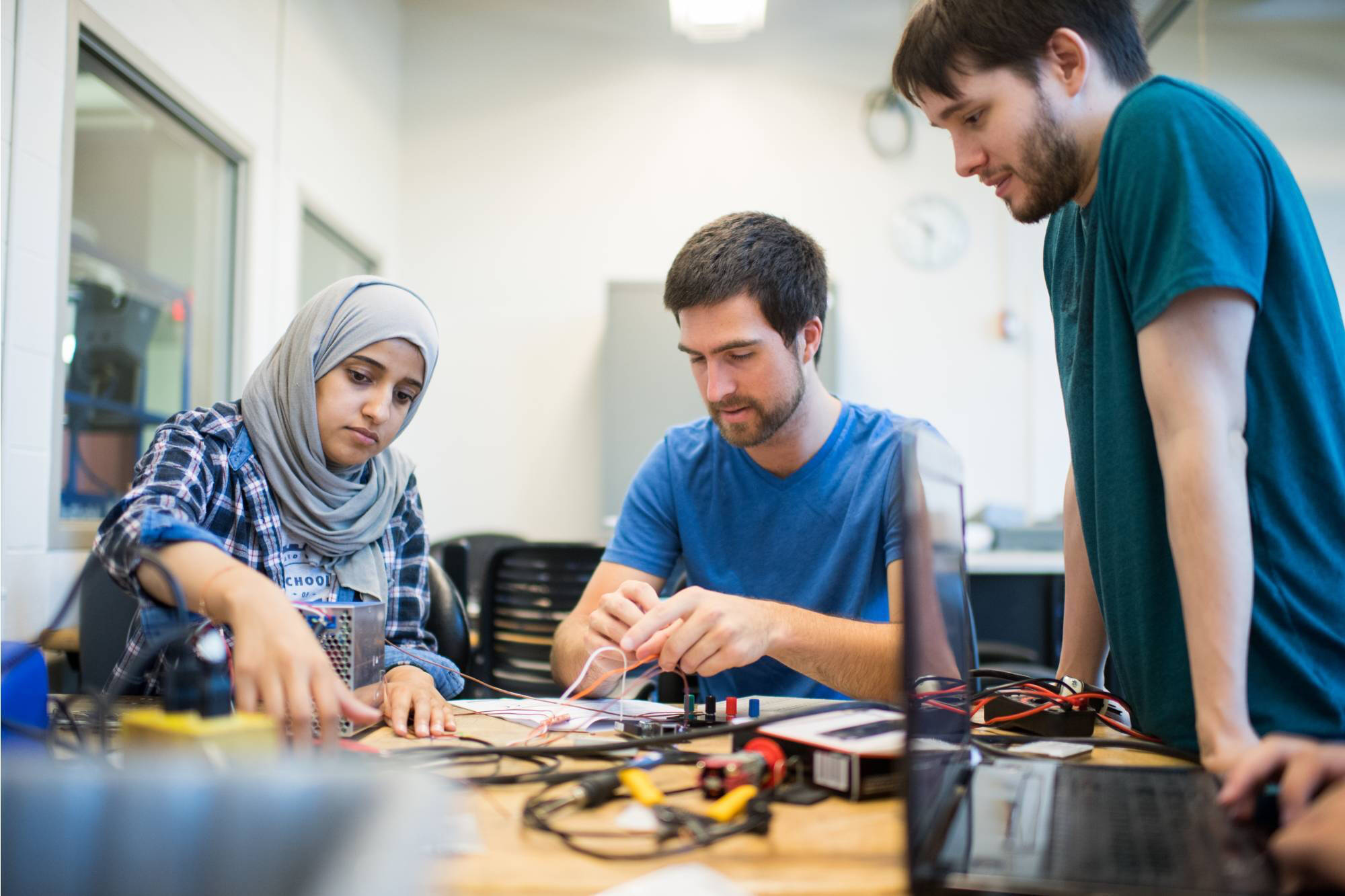 Three engineering students work together on a project.